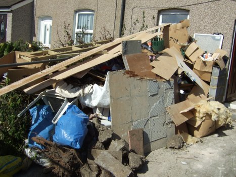 Team member carrying labeled bags during a residential rubbish clearance
